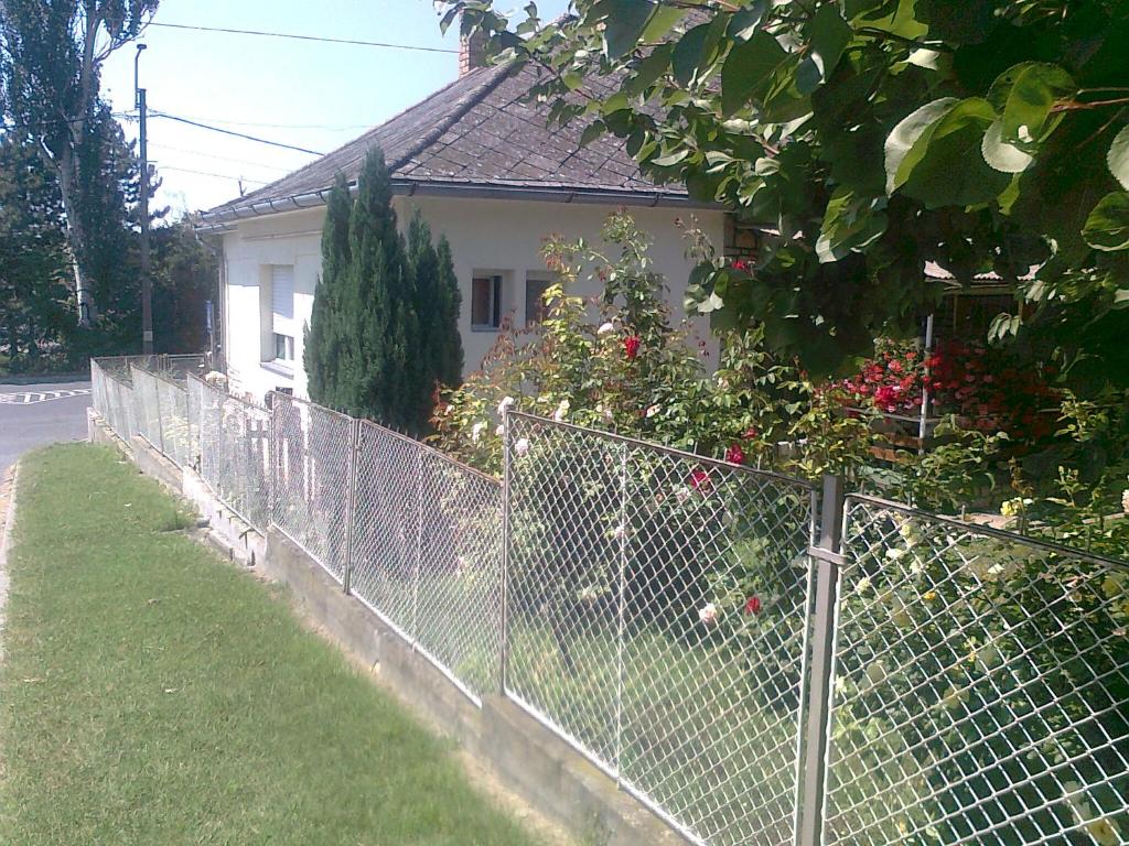 a fence in front of a house with flowers at Berci Villa in Balatonboglár