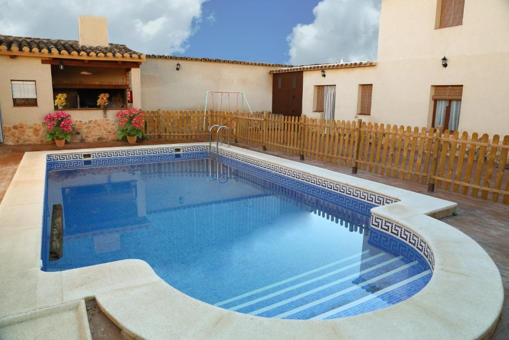 a swimming pool in a yard next to a house at La Quinteria de Sancho in Argamasilla de Alba