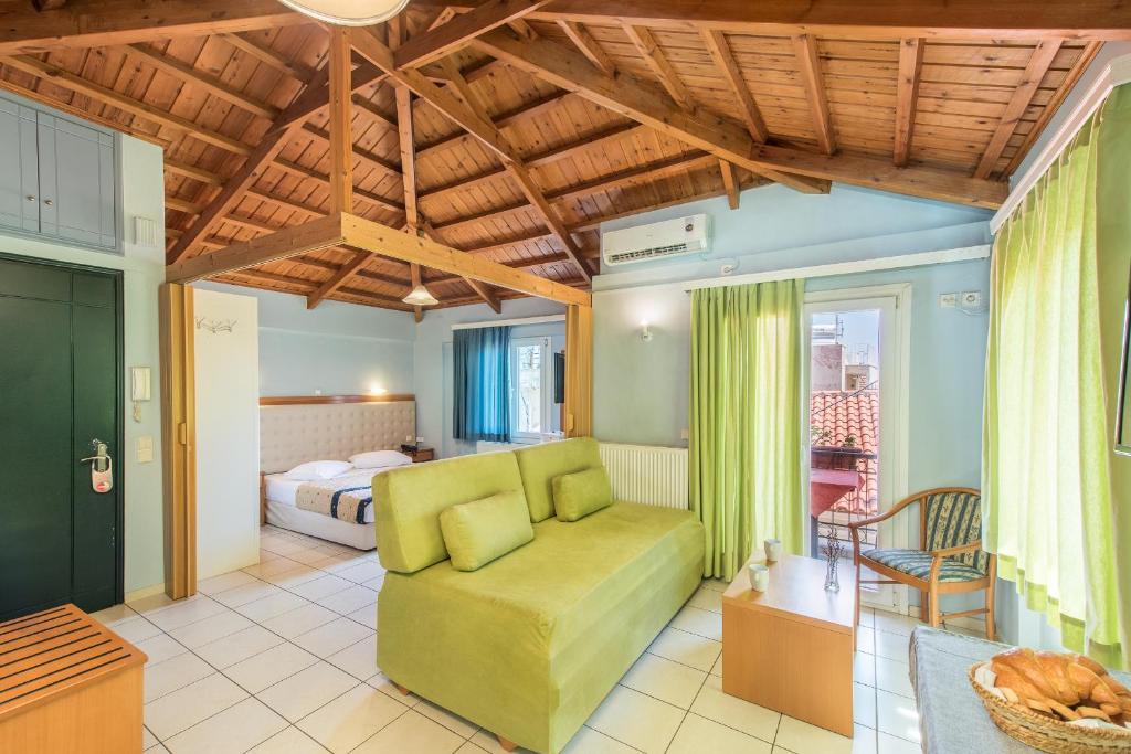 a living room with a green couch and a bed at Heliotrope The Studios in Mytilene