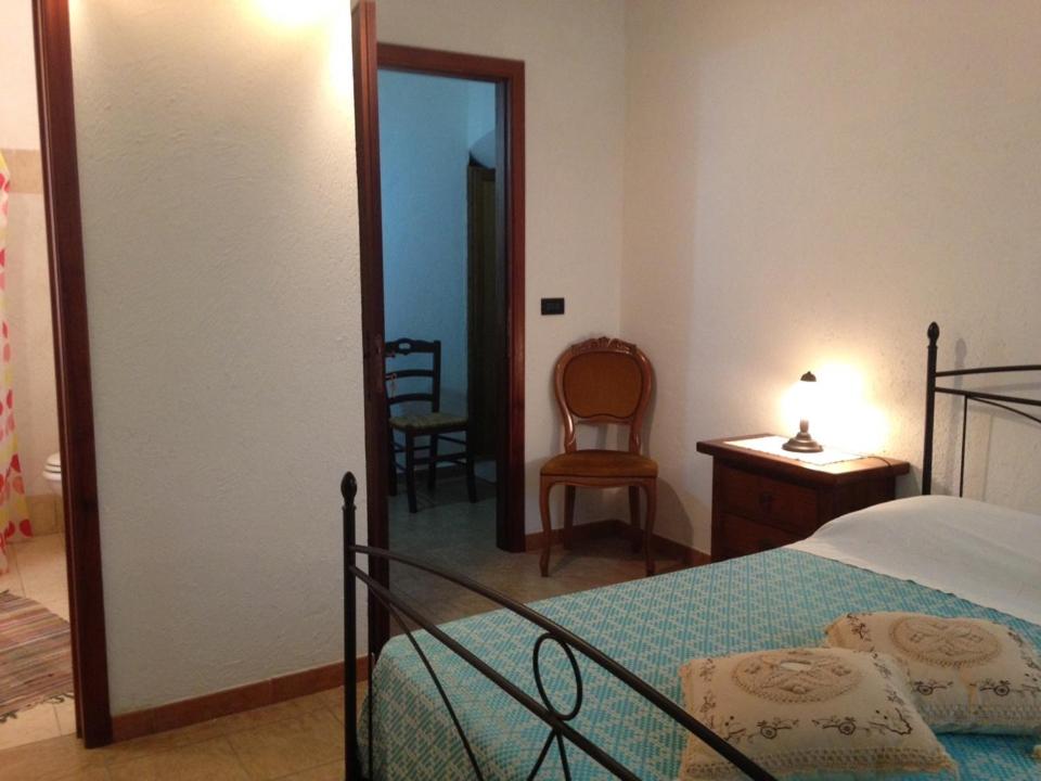 een slaapkamer met een bed, een bureau en een stoel bij Penisola Verde b&b in Locri