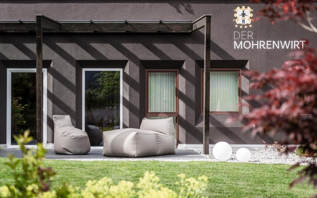 a house with two bean bags in front of it at Der Mohrenwirt **** in Burgusio