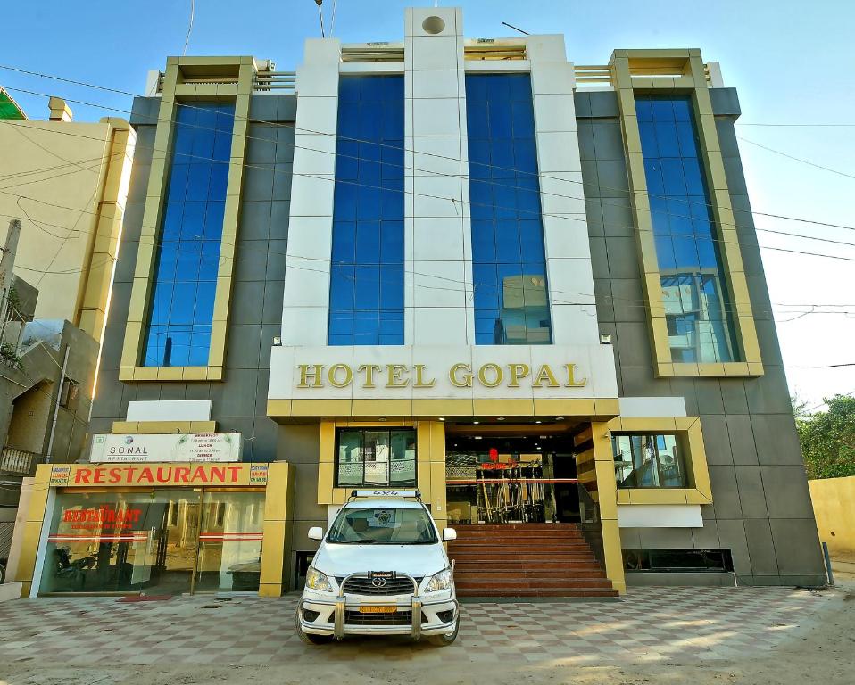 une voiture garée devant un portail d'hôtel dans l'établissement Hotel Gopal, à Dwarka
