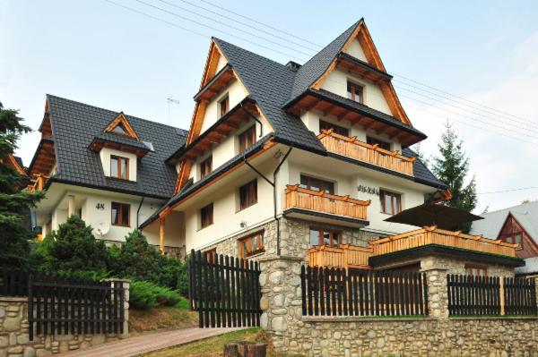 a large house with a fence in front of it at Willa Wiktoria in Bukowina Tatrzańska