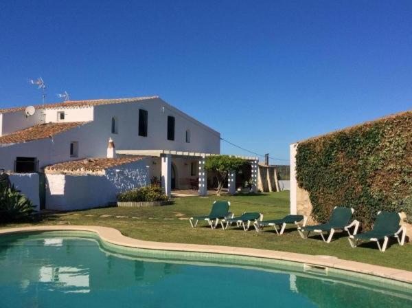 una casa con sillas y una piscina en Agroturismo Biniai Nou, en Mahón