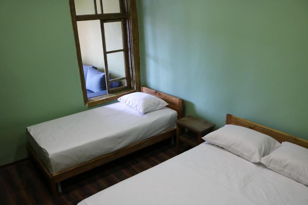 two beds in a room with a mirror at Dilijan Town Inn in Dilijan