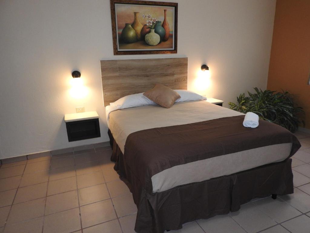 Bett in einem Zimmer mit zwei eingeschalteten Lampen in der Unterkunft Dreams Miramar in San Juan