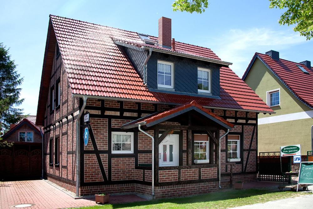 a house with a red roof on a street at Spreewaldpension Andreas Krüger in Schlepzig