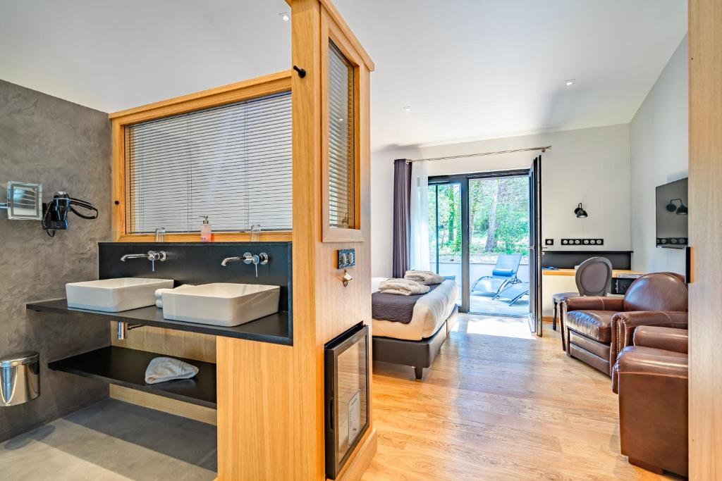 d'une salle de bains avec lavabo et d'une chambre. dans l'établissement Hôtel Ile de Ré, au Bois-Plage-en-Ré