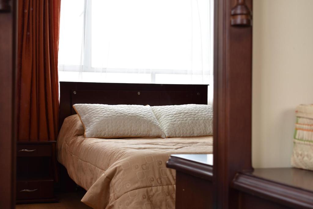 a bedroom with a bed with a window at Hotel Suyusama in Ipiales