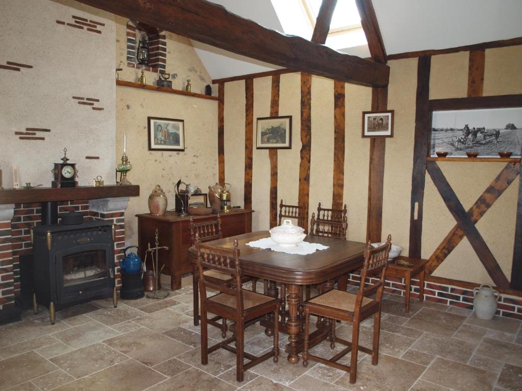 a dining room with a table and a fireplace at Gîtes les Terriers in Saint-Jean-Froidmentel