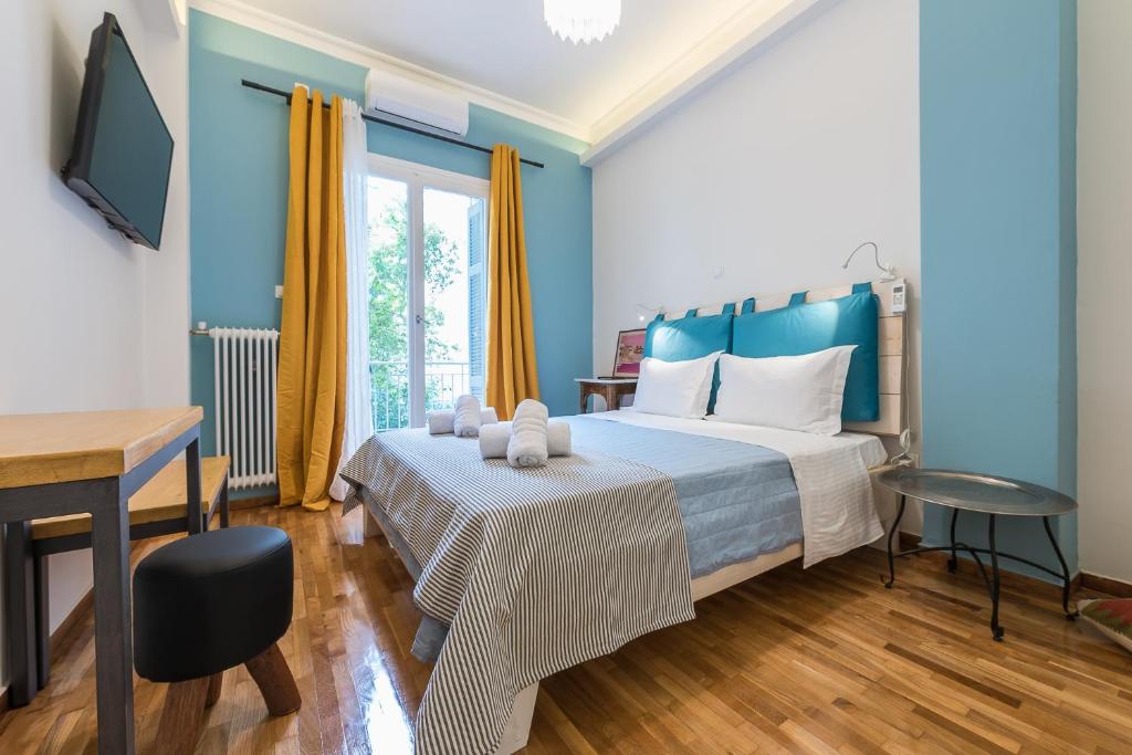 a bedroom with a bed and a desk and a television at Splash Of Glam I 10 steps from Acropolis in Athens