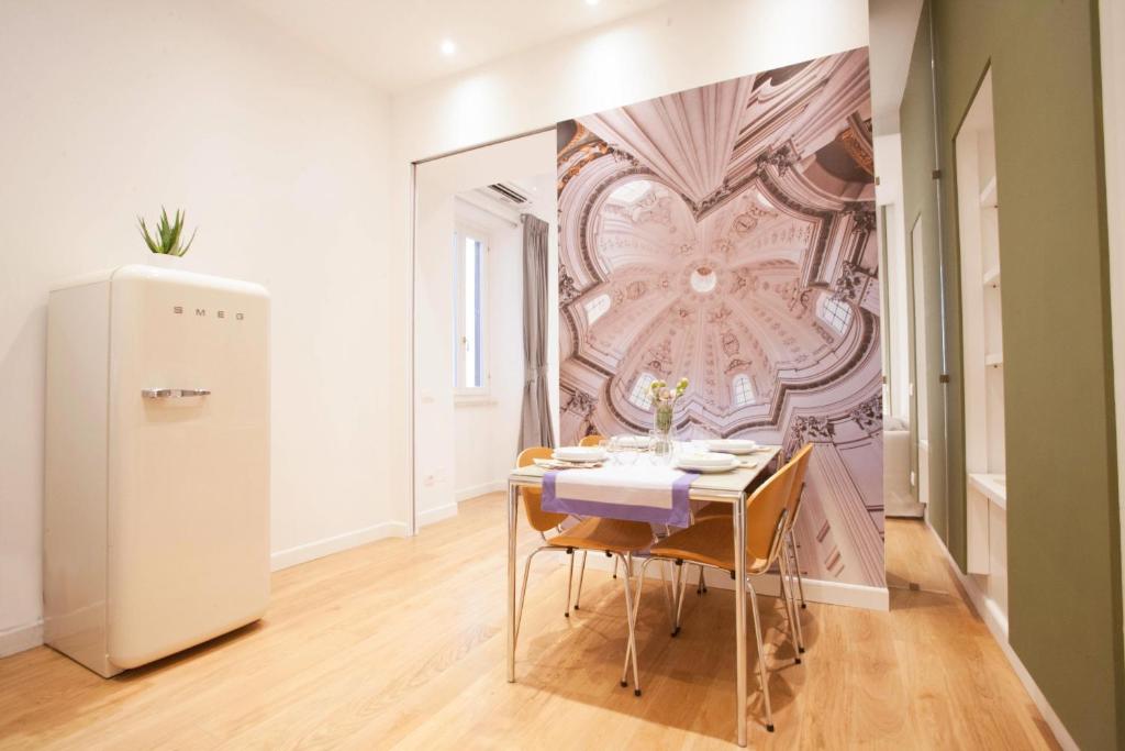 ein Esszimmer mit einem Tisch und einem Wandbild in der Unterkunft Corso 277 Apartment in Rom