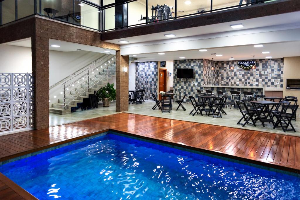 una gran piscina en el vestíbulo con un restaurante en Solar Plaza Hotel, en Fernandópolis