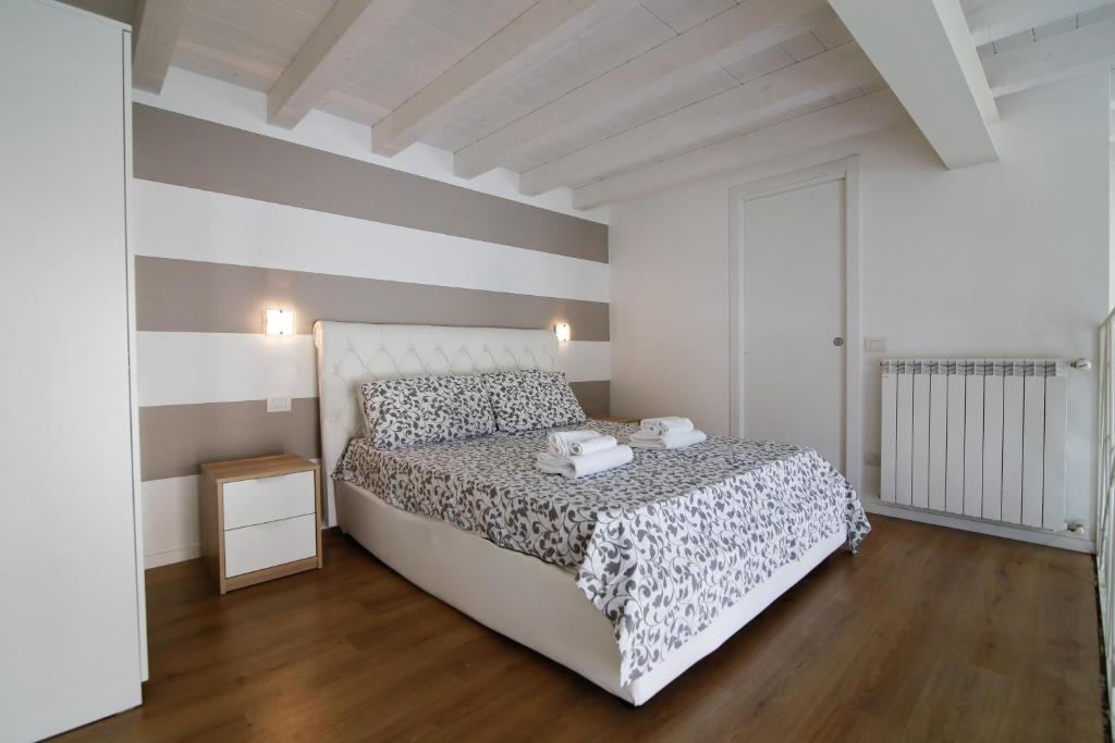 um quarto com uma cama e uma parede listrada em Conte Durini Apartments & Rooms em Arcore