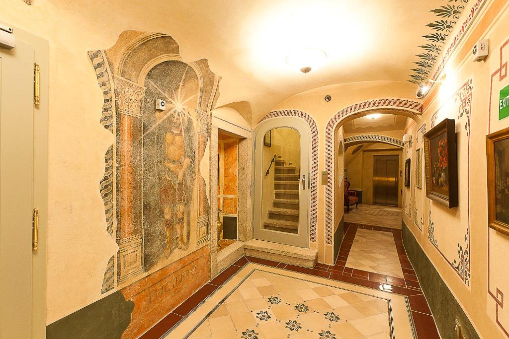 a hallway with mosaics on the walls of a building at Hotel Krčínův Dům in Český Krumlov