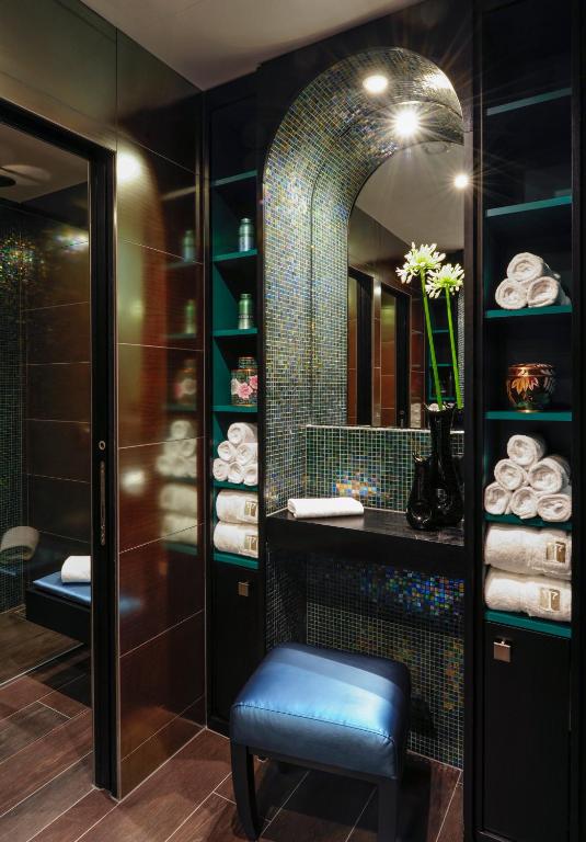 a bathroom with a stool and a mirror at Hôtel Tiffany by Fassbind in Geneva