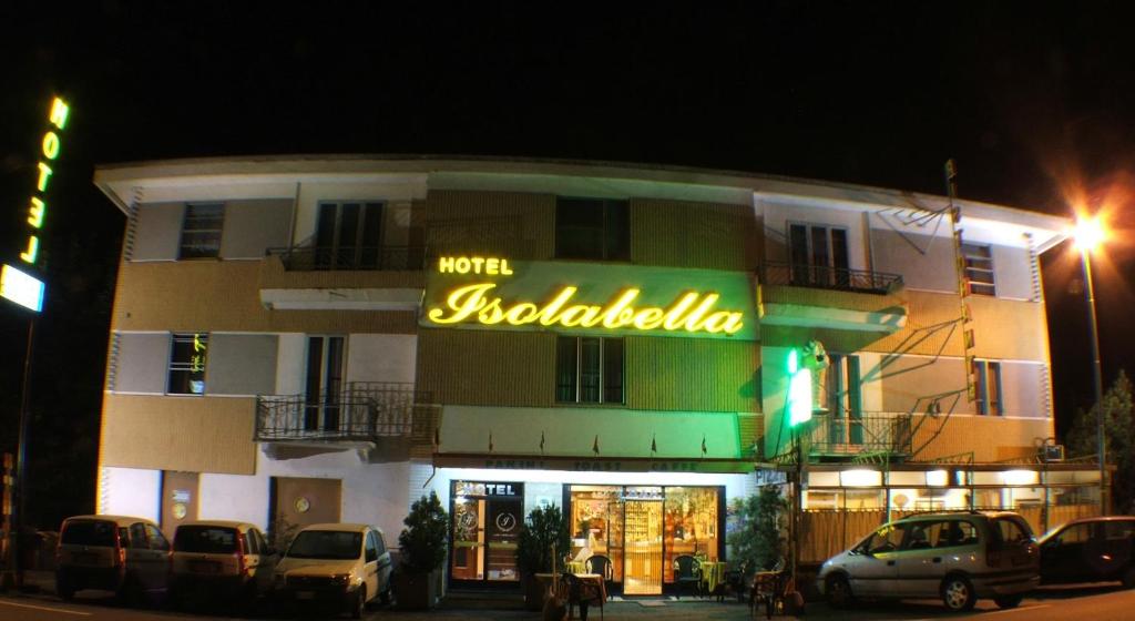 um edifício com um letreiro de néon em frente em Hotel Isolabella em Bussoleno