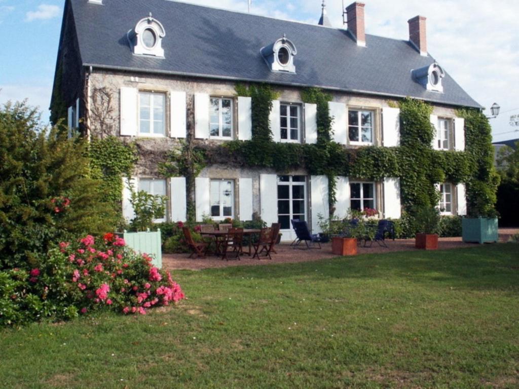 Una gran casa blanca con hiedra. en Chambres d'Hôtes - Domaine Des Perrières, en Crux-la-Ville