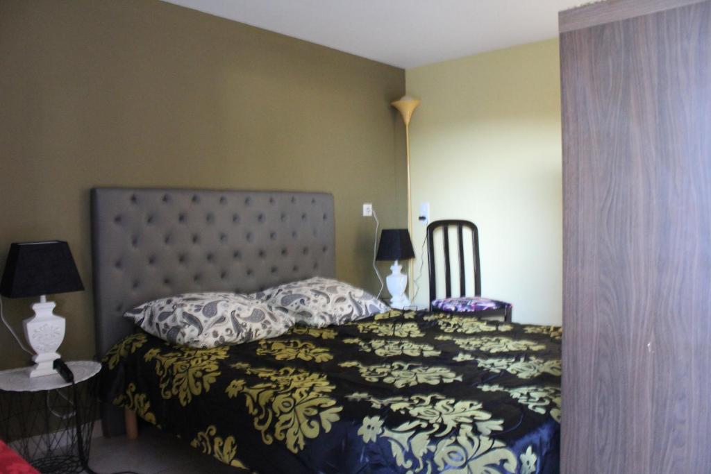a bedroom with a bed with a black and white comforter at Le Fauverney Lodge in Fauverney