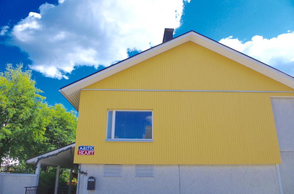 una casa amarilla con un letrero que dice "comer alquiler" en GuestHouse Arctic Heart, en Rovaniemi