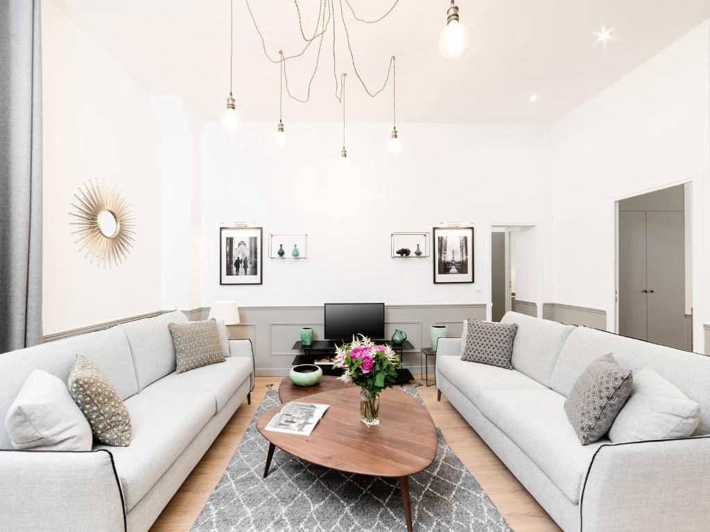 - un salon avec deux canapés blancs et une table dans l'établissement LivinParis - Luxury 3 & 4 Bedrooms Montmartre I, à Paris