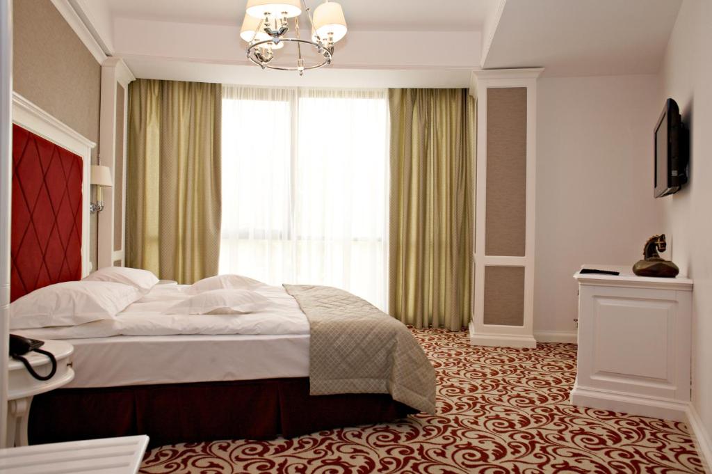 a bedroom with a large bed and a window at Hotel Bellaria in Iaşi