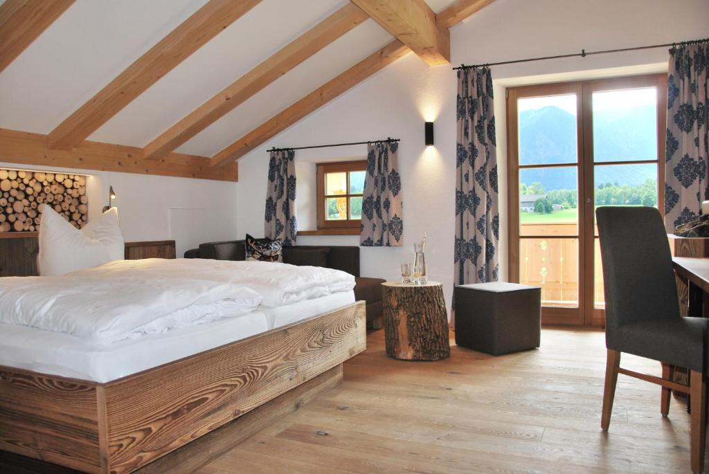 een slaapkamer met een bed, een bureau en een raam bij s´Quartier am Schliersee in Schliersee