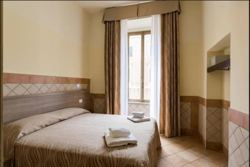 1 dormitorio con 1 cama con 2 toallas en Alex Romano, en Roma