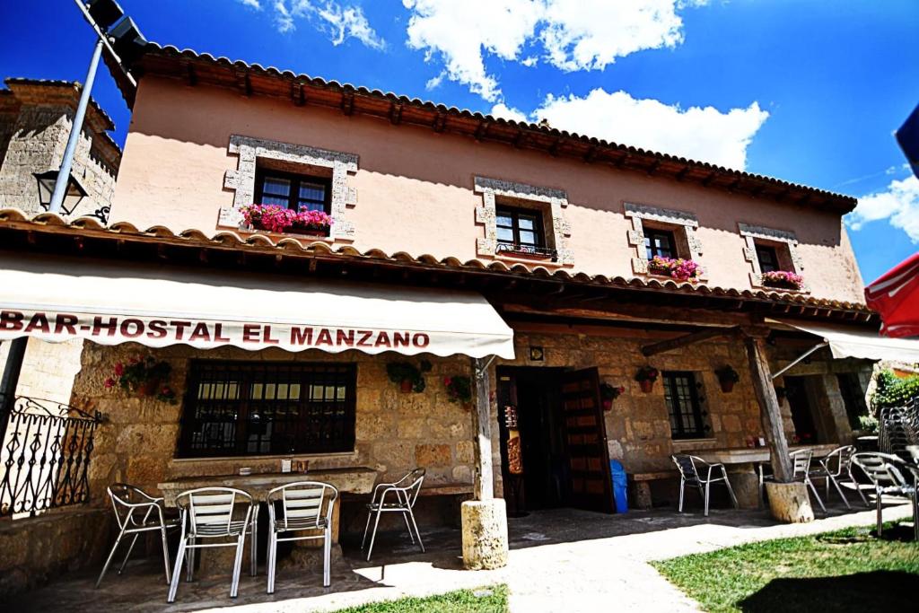 a building with tables and chairs in front of it at El manzano in Castrojeriz