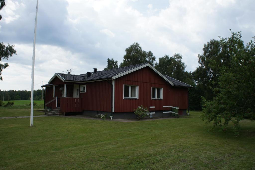 una casa roja en un campo con un patio verde en Kalv-Fegen 1, en Kalv