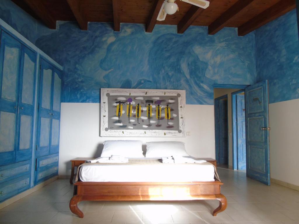 a bedroom with a bed and a blue wall at Luxury Penthouse on the square with sea view in Sal Rei