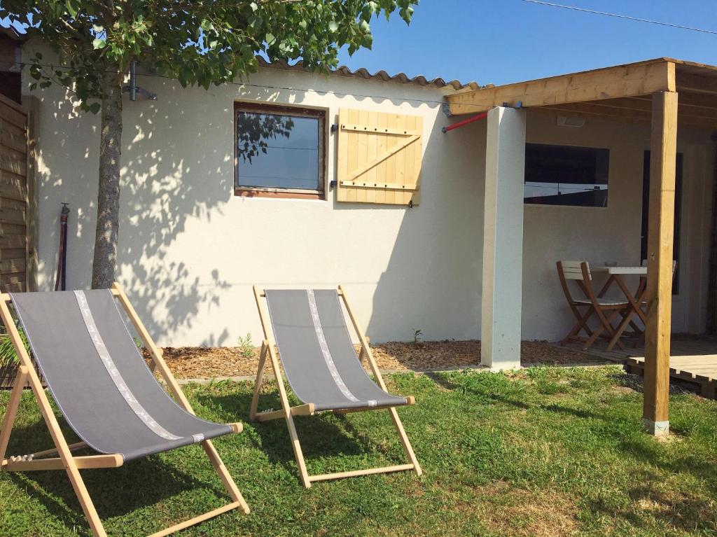 zwei Gartenstühle im Gras vor einem Haus in der Unterkunft Les Libellules in Les Sables-dʼOlonne
