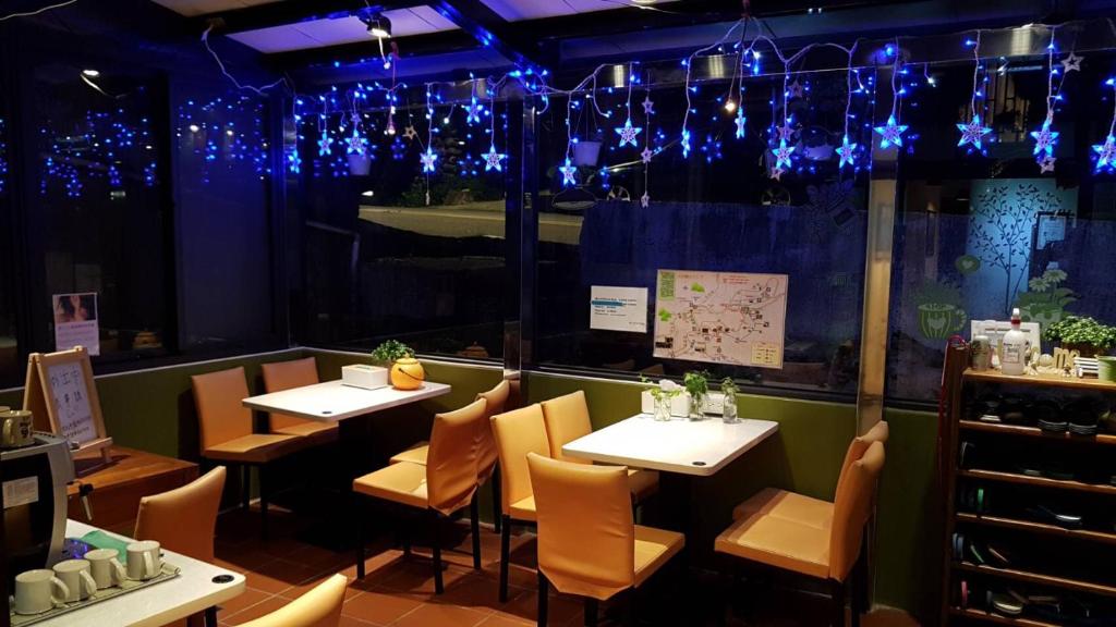 a restaurant with tables and chairs and blue lights at Corner Inn九份住宿I 小角落民宿I 機車租借I日夜間導覽 in Jiufen