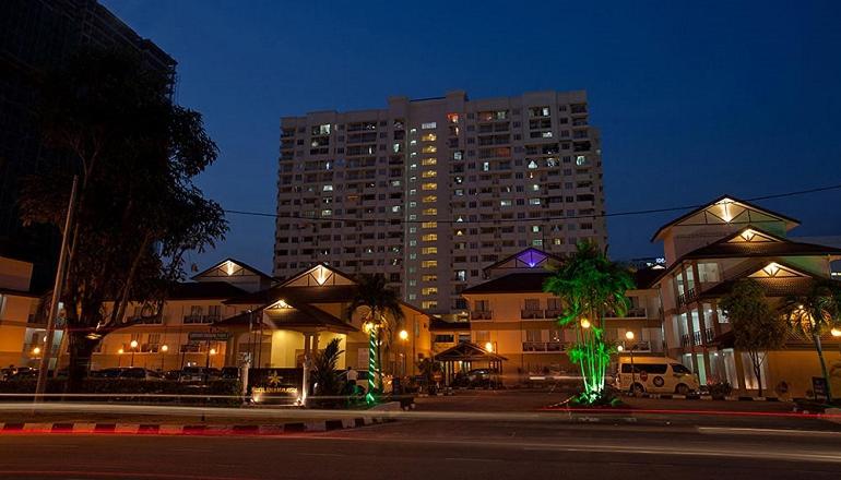 a tall building at night with a building at Hotel Seri Malaysia Pulau Pinang in Bayan Lepas