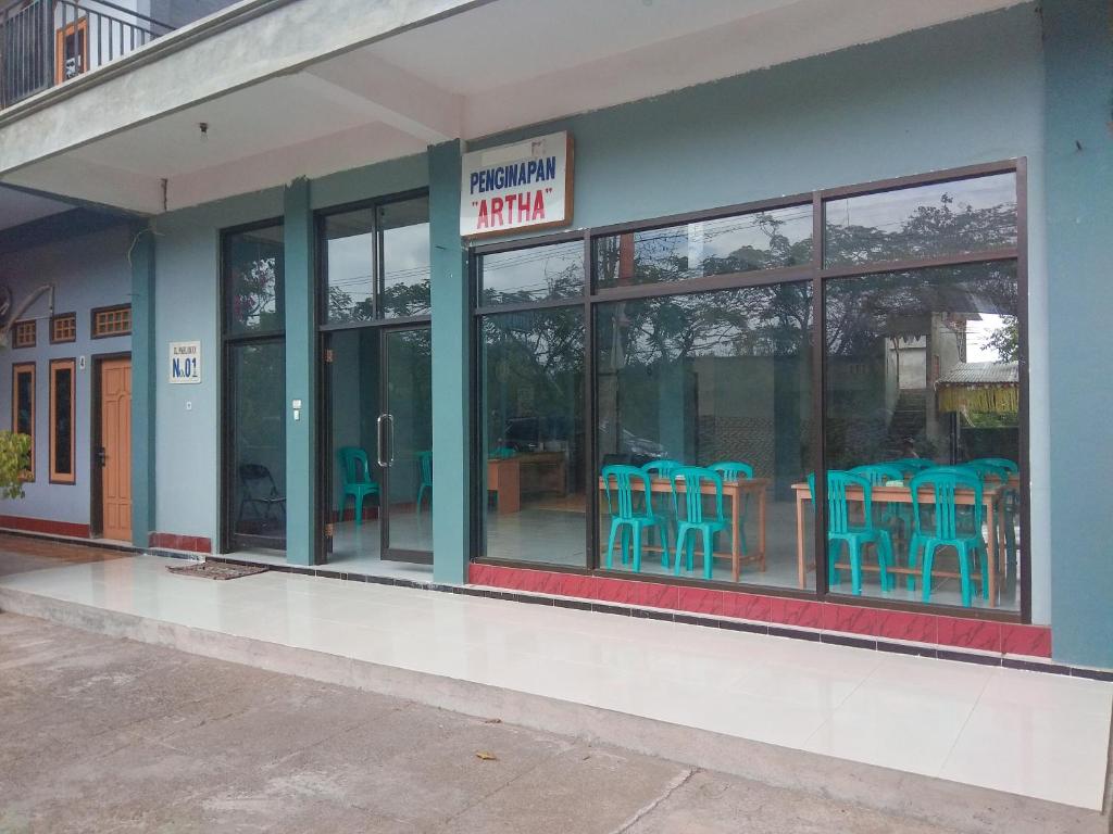 a restaurant with blue chairs outside of a building at Penginapan Artha in Praya
