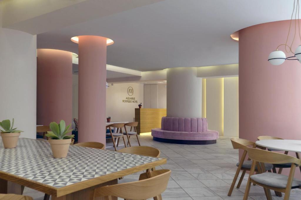 Cette chambre comprend une table, des chaises, des tables et des chaises. dans l'établissement Aquarius Boutique Hotel, à Réthymnon