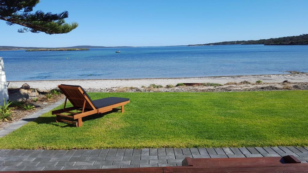 ławka siedząca na trawie blisko wody w obiekcie Vandy's shack at Mount Dutton Bay - ideal for couples and small families w mieście Mount Dutton Bay West