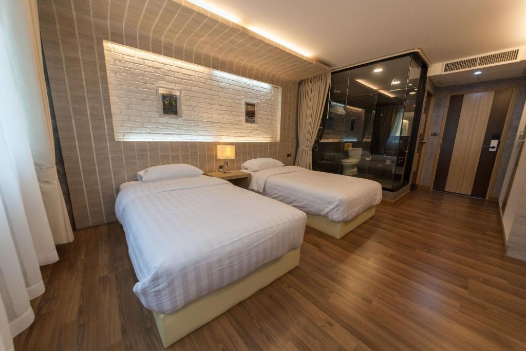 a hotel room with two beds and a mirror at Feel Nimman Boutique in Chiang Mai