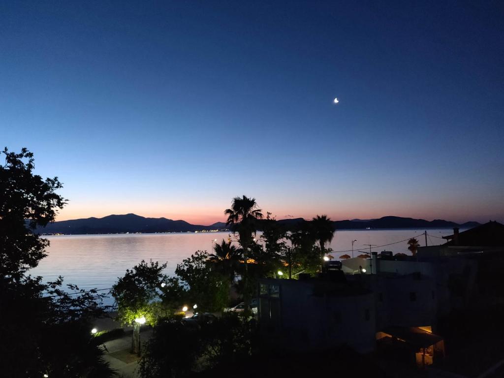 una vista de un cuerpo de agua por la noche en Lerna Rooms en Míloi