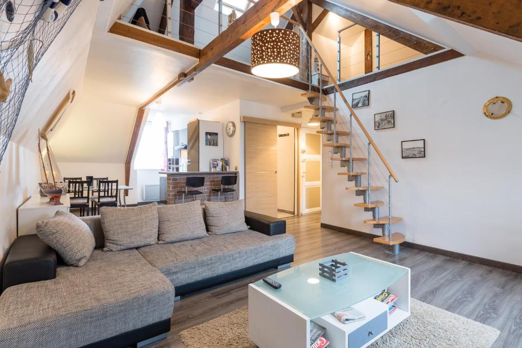 een woonkamer met een bank en een tafel bij Duplex in Saint-Malo