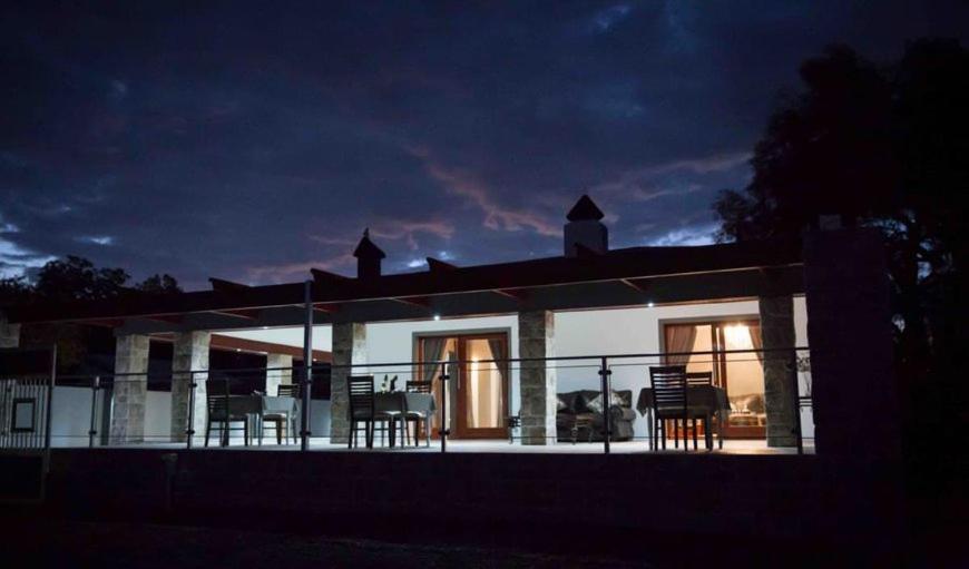 a house with chairs on the balcony at night at Vaal De Vue Guesthouse in Christiana