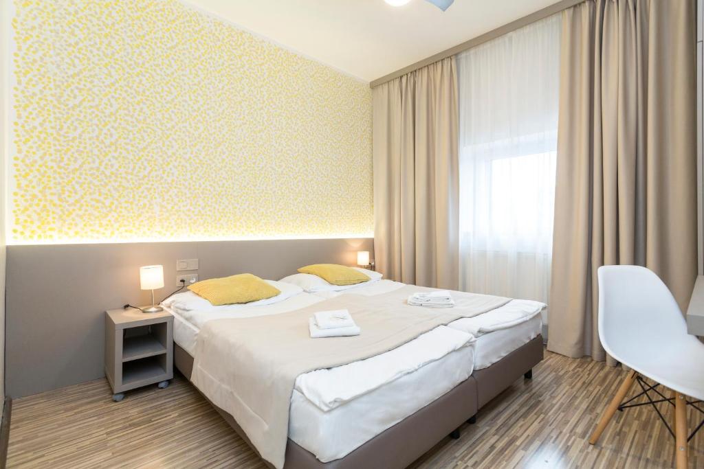 a hotel room with a large bed and a chair at Pension Akat in Prague