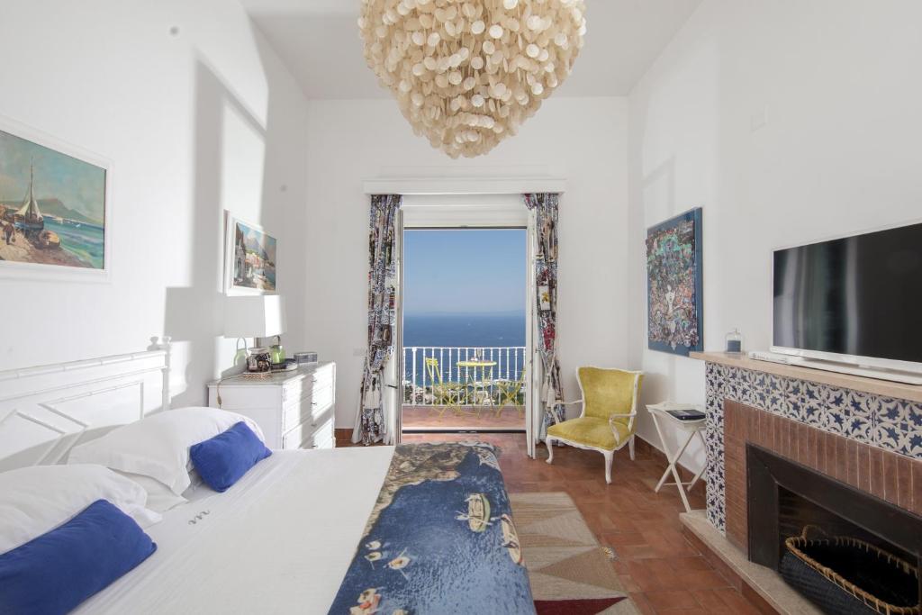 a bedroom with a bed and a fireplace and a television at Casa Marta Capri in Capri