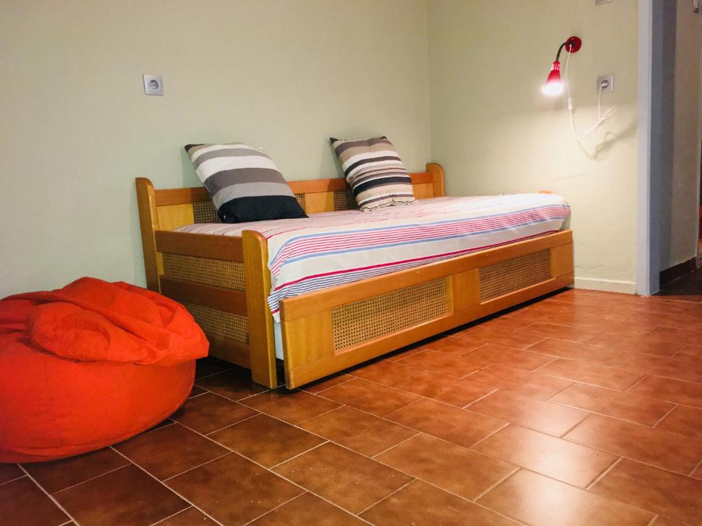 アギオス・イオアニス・ペリオンにあるElsa Apartmentのベッドルーム(木製ベッド1台、オットマン付)