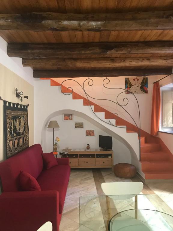 salon z czerwoną kanapą i schodami w obiekcie Pisciotta House w mieście Pisciotta