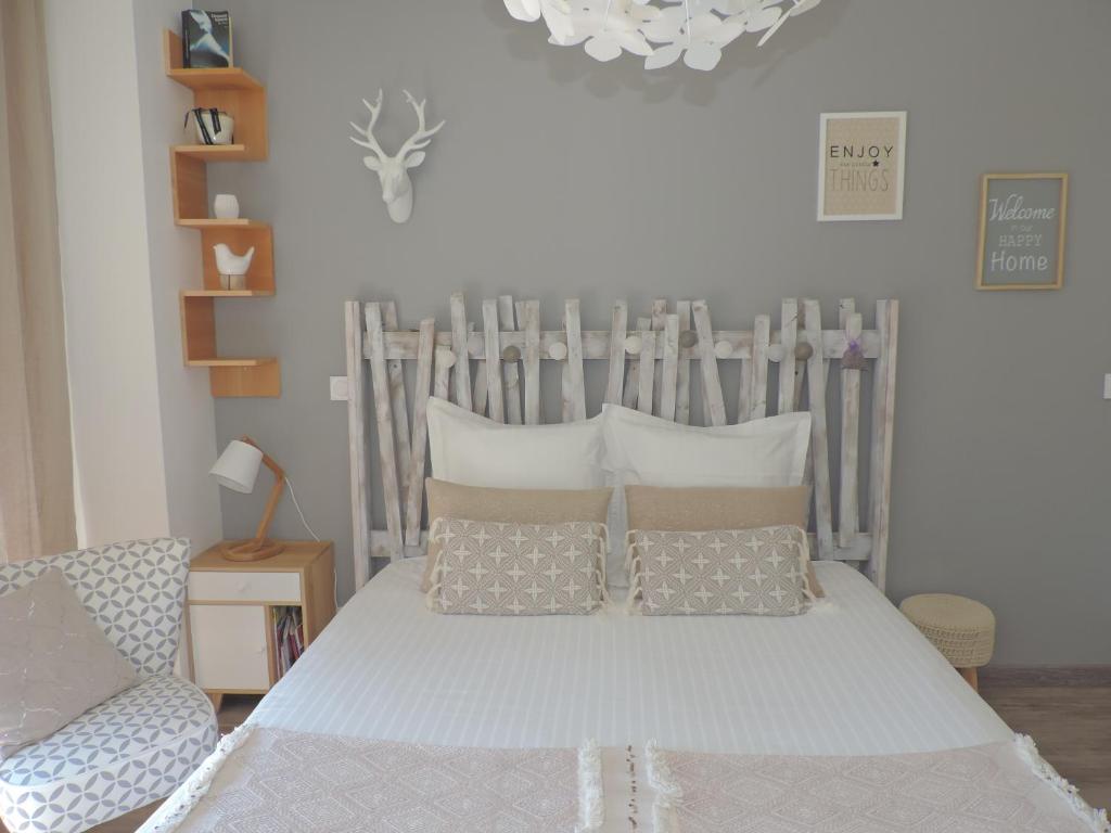 1 dormitorio con cama con cabecero de madera y almohadas en Studios Nuitée en Provence en Aix-en-Provence