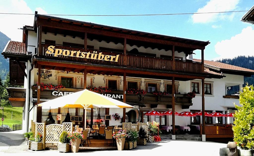 a building with an umbrella in front of it at Appartements Sportsüberl in Berwang