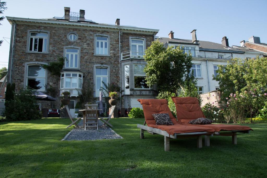 a couch sitting in the grass in front of a building at Hotel Dufays in Stavelot