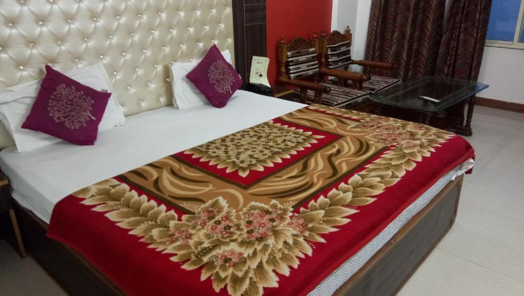 a large bed with a red and gold blanket at Delightful Stay Over looking Himalayas in Mussoorie