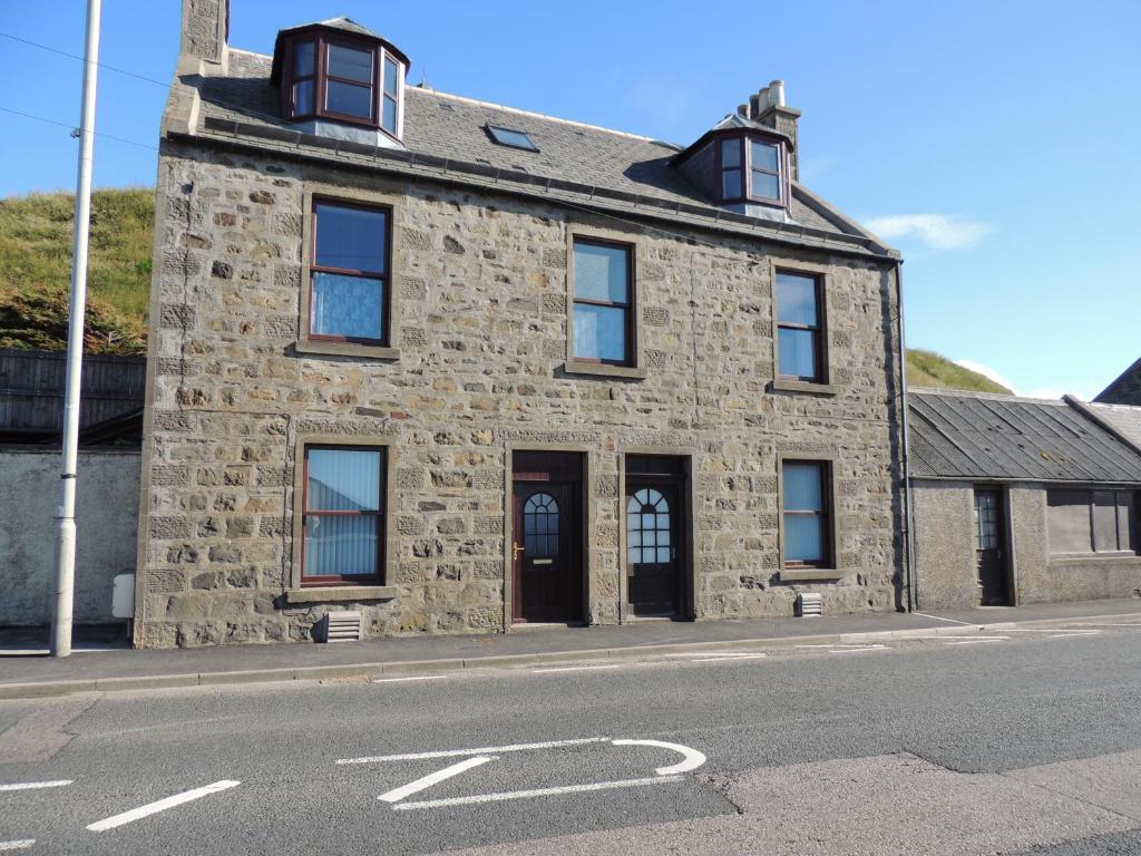 an old stone building on the side of a street at 5A Union Road in Macduff